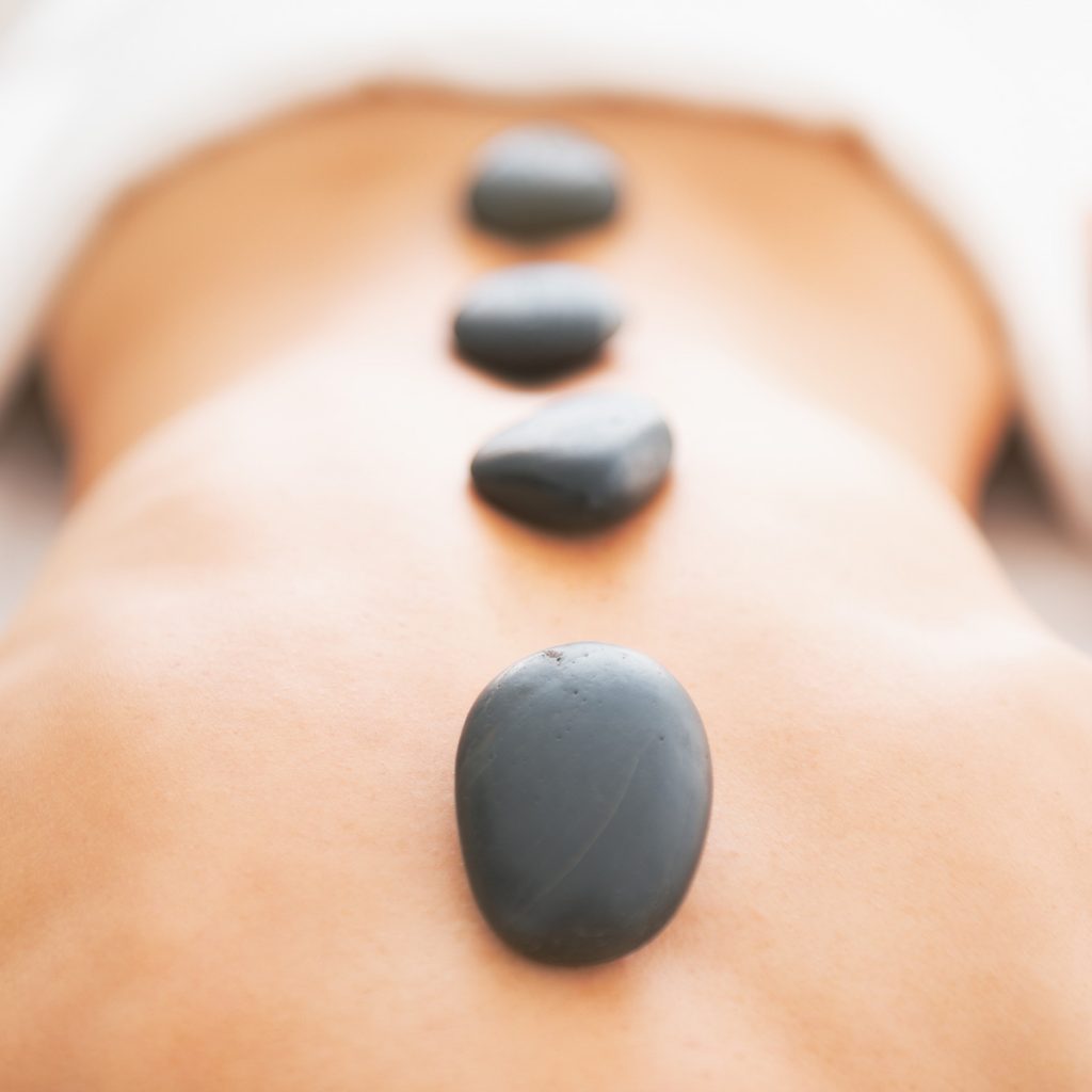hot stones on a womans back during a hot stone massage treatment at omaha massage and wellness center