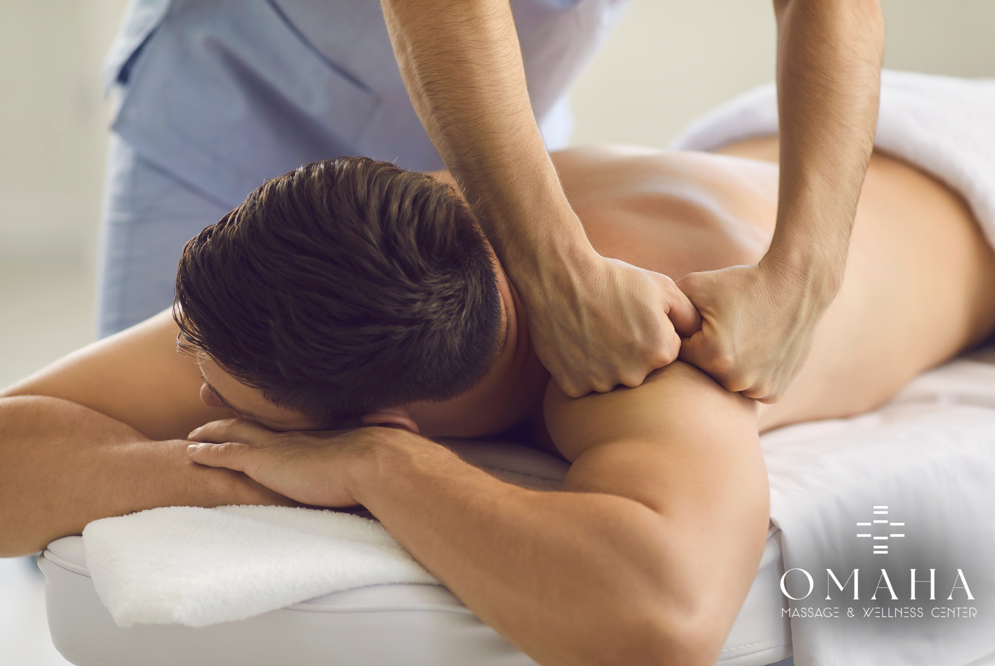 Omaha massage therapist providing deep tissue massage to a male client at Omaha Massage & Wellness Center.